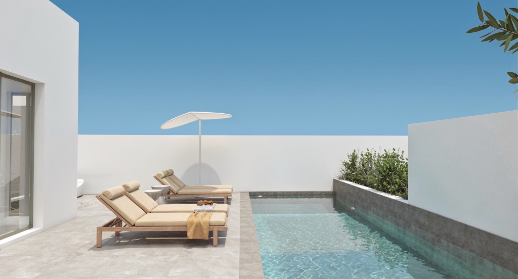 Nocturne's private pool with a white parasol and twin loungers, walled in white.
