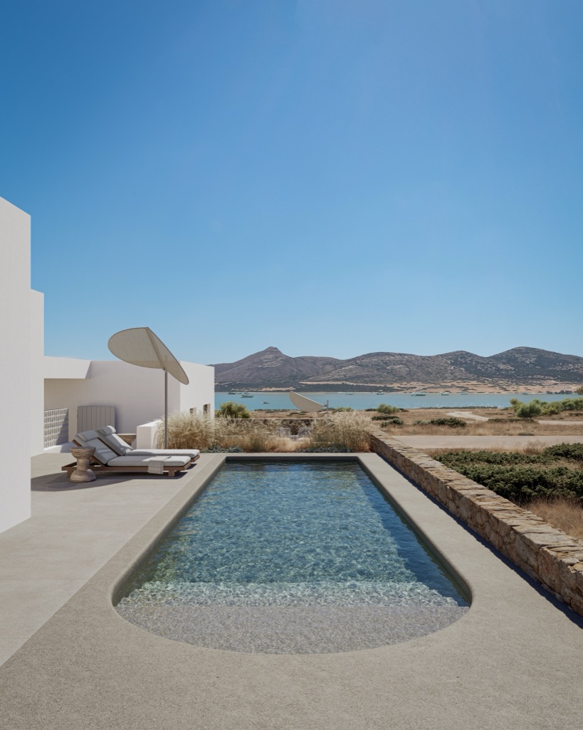 Long pool facing the sea, with parasol and lounge chairs.